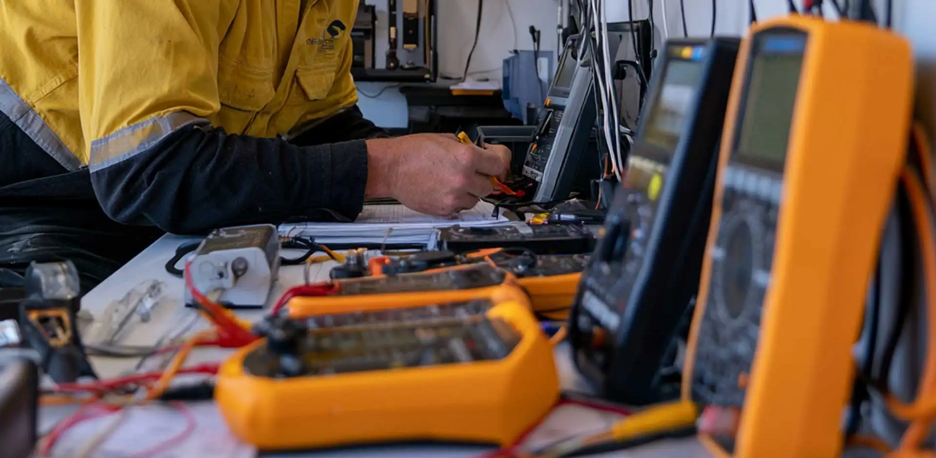 Technician calibrating test meters at a workbench